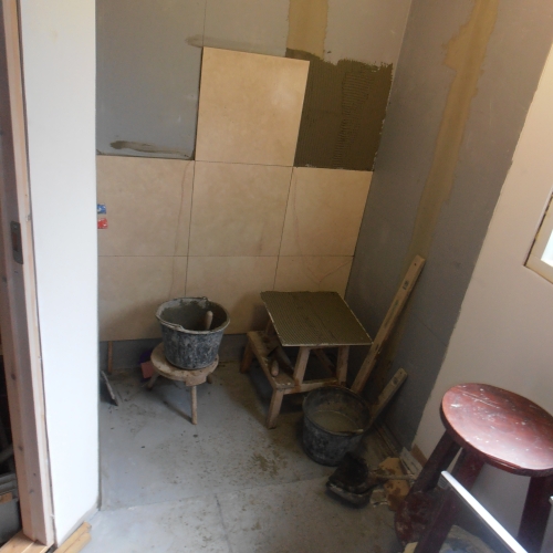 Opsætning af fliser under renovering af nyt badeværelse i Udsholt
